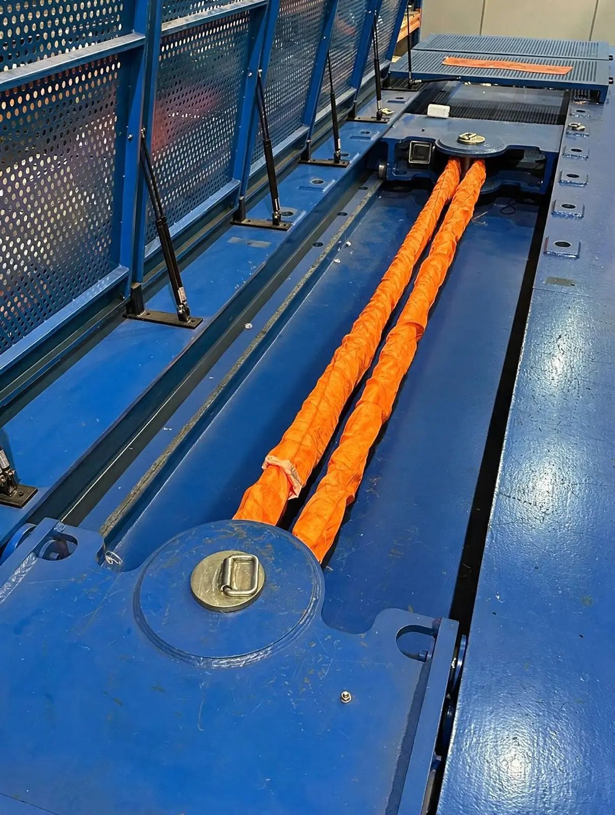 Cintas tubulares laranja da Qualimax posicionadas na máquina azul de ensaio de tração